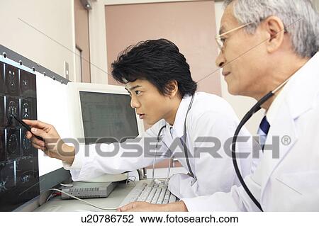 Stock Image - Doctors looking at X-ray. Fotosearch