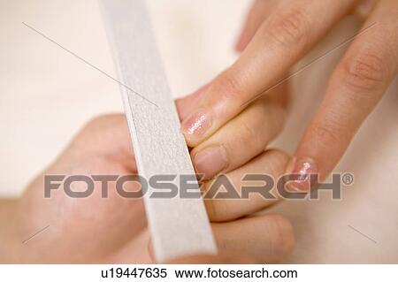 Stock Photography - Woman taking a manicure at beauty-treatment clinic. Fotosearch