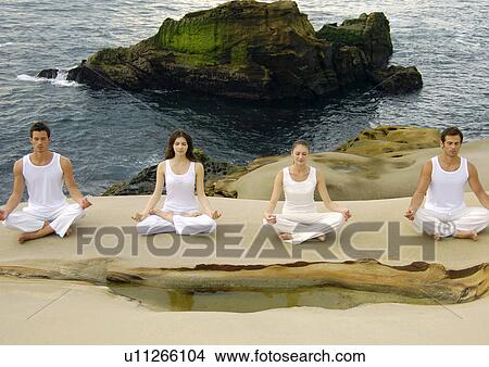 High angle view of two young men and two young women practicing yoga View Large Photo Image Picture - High angle view of two young men and two young women practicing yoga. Fotosearch