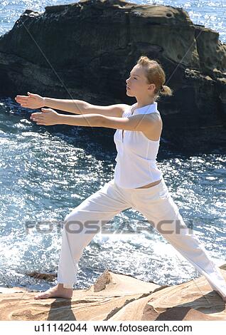 Side profile of a young woman practicing yoga View Large Photo Image Picture - Side profile of a young woman practicing yoga. Fotosearch
