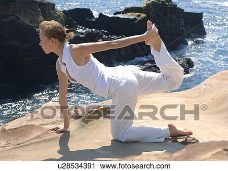 Side profile of a young woman practicing yoga View Large Photo Image Stock Image - Side profile of a young woman practicing yoga. Fotosearch