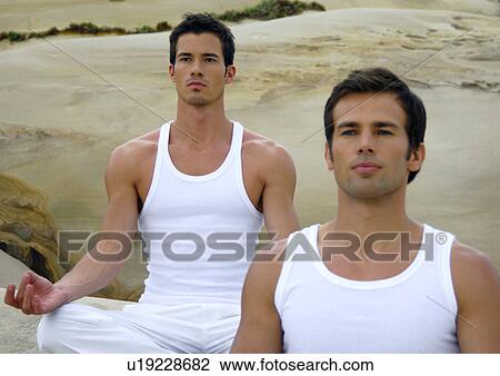 Stock Image - Two young men practicing yoga. Fotosearch
