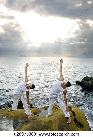 Two young men practicing yoga View Large Photo Image Stock Photo - Two young men practicing yoga. Fotosearch