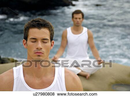 Stock Photo - Two young men practicing yoga. Fotosearch