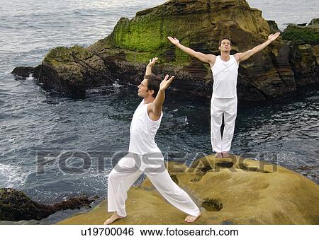 Stock Photograph - Two young men practicing yoga. Fotosearch