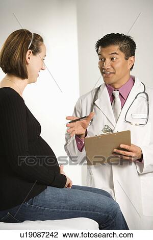 Asian American male doctor examining Caucasian pregnant female patient. View Large Photo Image Stock Image - Asian American male doctor examining Caucasian pregnant female patient.. Fotosearch