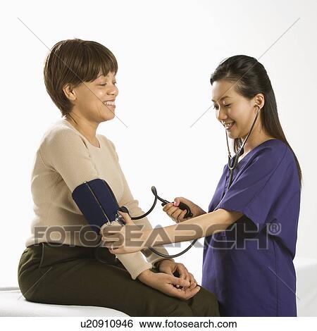 Asian Chinese mid-adult female medical practitioner checking blood pressure of African American middle-aged female patient. View Large Photo Image Stock Photograph - Asian Chinese mid-adult female medical practitioner checking blood pressure of African American middle-aged female patient.. Fotosearch