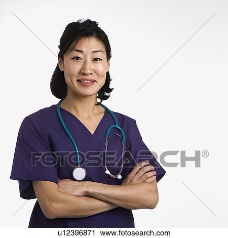 Stock Image - Asian woman doctor half length portrait against white background.. Fotosearch