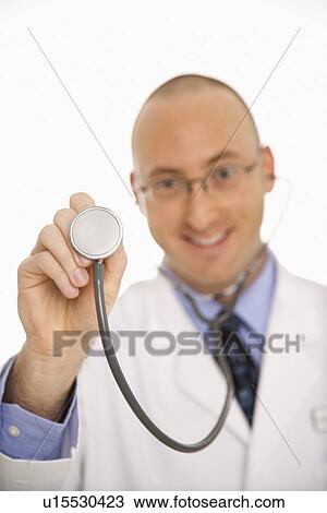 Caucasian mid adult male physician holding up end of stethescope. View Large Photo Image Stock Image - Caucasian mid adult male physician holding up end of stethescope.. Fotosearch