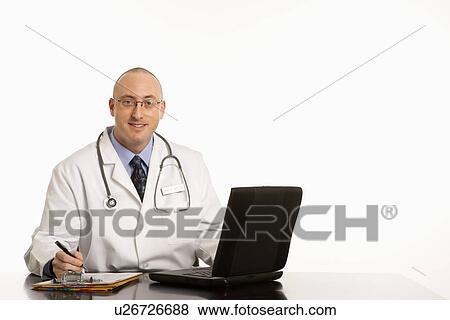 Caucasian mid adult male physician sitting at desk with laptop computer. View Large Photo Image Stock Photo - Caucasian mid adult male physician sitting at desk with laptop computer.. Fotosearch