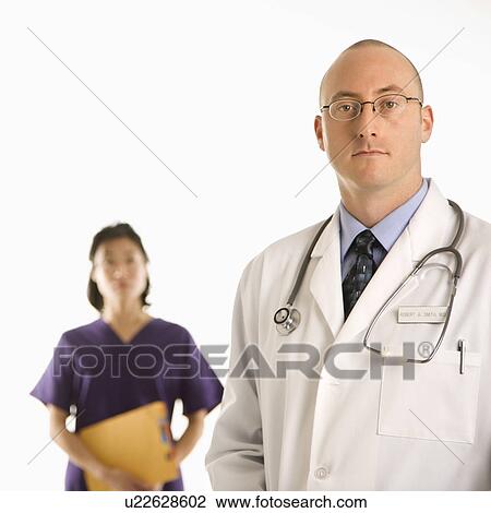 Caucasian mid adult male physician with Asian woman doctor. View Large Photo Image Stock Image - Caucasian mid adult male physician with Asian woman doctor.. Fotosearch