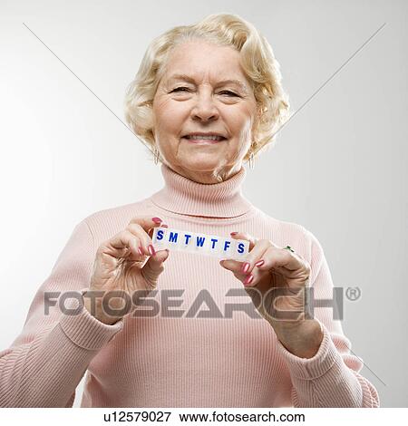 Caucasian senior woman holding pill box and smiling at viewer. View Large Photo Image Stock Photo - Caucasian senior woman holding pill box and smiling at viewer.. Fotosearch