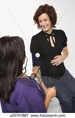 Pregnant Caucasian mid-adult woman having vital signs checked by nurse. View Large Photo Image Stock Photo - Pregnant Caucasian mid-adult woman having vital signs checked by nurse.. Fotosearch