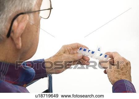 Profile view of Caucasion elderly man holding seven-day pill box with Thursday open. View Large Photo Image Stock Photo - Profile view of Caucasion elderly man holding seven-day pill box with Thursday open.. Fotosearch