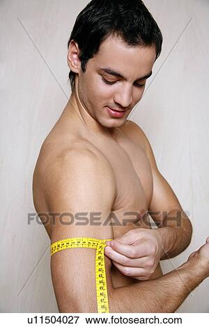 Stock Photo - Man measuring his arm muscle. Fotosearch