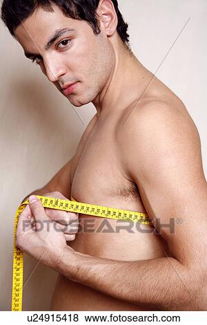Man measuring his chest View Large Photo Image Stock Photo - Man measuring his chest. Fotosearch