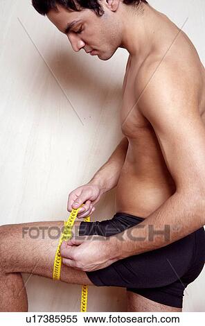Stock Photography - Man measuring his thigh. Fotosearch