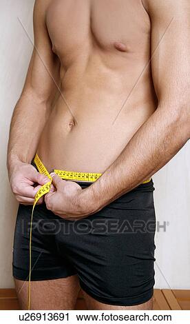 Man measuring his waist View Large Photo Image Stock Image - Man measuring his waist. Fotosearch