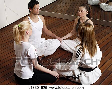 Participants in a fitness class meditating View Large Photo Image Stock Photograph - Participants in a fitness class meditating. Fotosearch