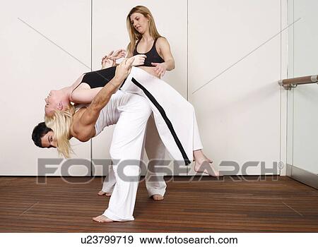 Partners practicing flexibility in yoga and Capoeira programs View Large Photo Image Stock Photo - Partners practicing flexibility in yoga and Capoeira programs. Fotosearch