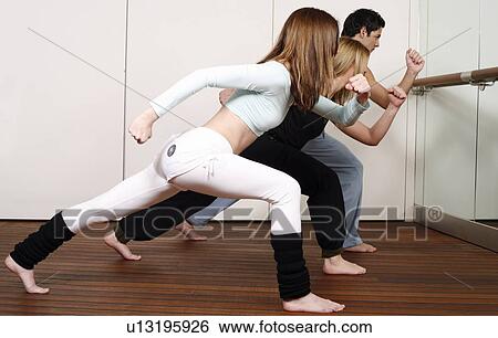 Stock Photograph - Students learning a basic Capoeira move. Fotosearch