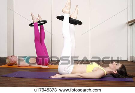 Two young women performing a pilates exercise View Large Photo Image Stock Image - Two young women performing a pilates exercise. Fotosearch