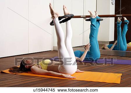 Two young women performing a pilates exercise View Large Photo Image Stock Photography - Two young women performing a pilates exercise. Fotosearch