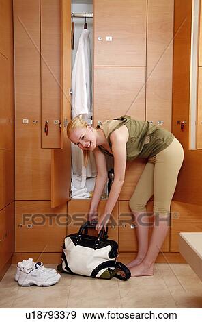 Stock Photo - Woman in locker room after work out. Fotosearch