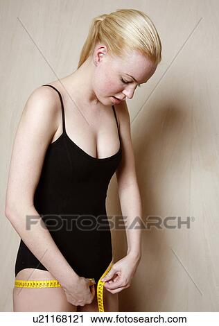 Woman measuring her waist View Large Photo Image Stock Image - Woman measuring her waist. Fotosearch