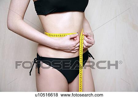 Woman measuring her waist View Large Photo Image Stock Photo - Woman measuring her waist. Fotosearch
