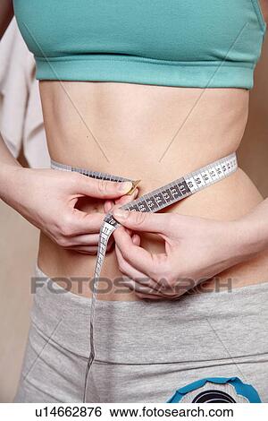 Woman measuring her waist View Large Photo Image Stock Photograph - Woman measuring her waist. Fotosearch