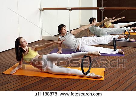 Young man and woman performing a pilates exercise View Large Photo Image Stock Photo - Young man and woman performing a pilates exercise. Fotosearch