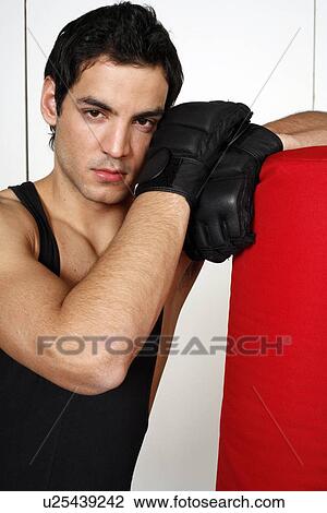 Young man leaning on punching bag View Large Photo Image Stock Image - Young man leaning on punching bag. Fotosearch