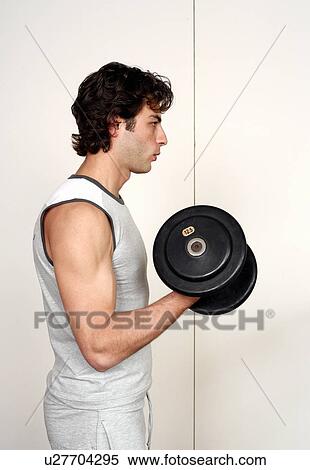 Young man lifting weights View Large Photo Image Stock Photography - Young man lifting weights. Fotosearch