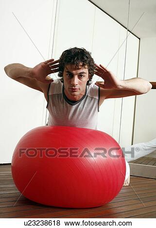 Young man performing a pilates exercise View Large Photo Image Stock Photo - Young man performing a pilates exercise. Fotosearch