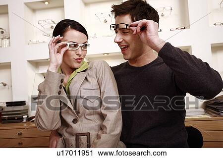 Couple trying on eyeglasses in store View Large Photo Image Stock Image - Couple trying on eyeglasses in store. Fotosearch