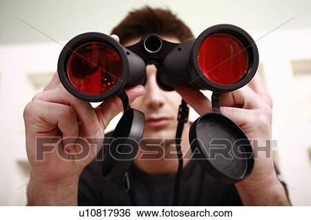Stock Photograph - Man with binoculars in eyeglass store. Fotosearch