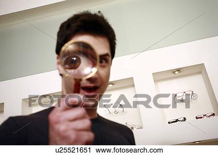 Man with magnifying glass on eye View Large Photo Image Stock Image - Man with magnifying glass on eye. Fotosearch