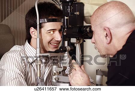 Optometrist examining patient View Large Photo Image Stock Photo - Optometrist examining patient. Fotosearch