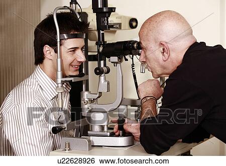 Stock Photograph - Optometrist examining patient. Fotosearch