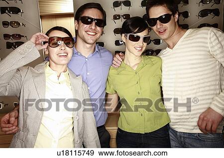 Two couples posing with sunglasses in store View Large Photo Image Stock Photo - Two couples posing with sunglasses in store. Fotosearch