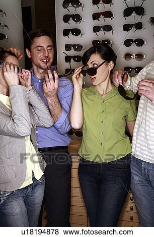 Two couples shopping for sunglasses in store View Large Photo Image Stock Photo - Two couples shopping for sunglasses in store. Fotosearch