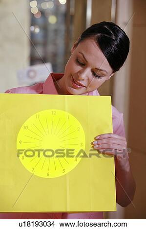 Picture - Woman holding optical chart. Fotosearch