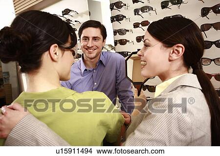 Woman trying on sunglasses in store View Large Photo Image Picture - Woman trying on sunglasses in store. Fotosearch