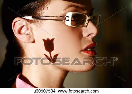 Woman wearing glasses with tulip shape on her face View Large Photo Image Picture - Woman wearing glasses with tulip shape on her face. Fotosearch