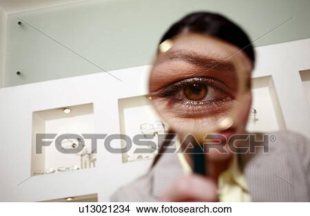 Woman with magnifying glass on eye View Large Photo Image Picture - Woman with magnifying glass on eye. Fotosearch