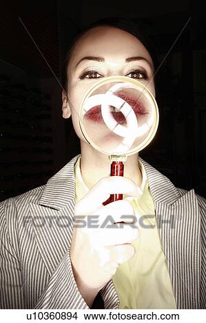 Picture - Woman with magnifying glass on mouth. Fotosearch