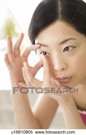Young Woman inserting contact lens, Close Up, Front View View Large Photo Image Stock Photography - Young Woman inserting contact lens, Close Up, Front View. Fotosearch