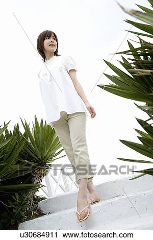 Young woman standing on stairs, low angle view View Large Photo Image Stock Image - Young woman standing on stairs, low angle view. Fotosearch
