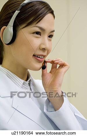 Female scientist wearing a headset, smiling, side view View Large Photo Image Picture - Female scientist wearing a headset, smiling, side view. Fotosearch